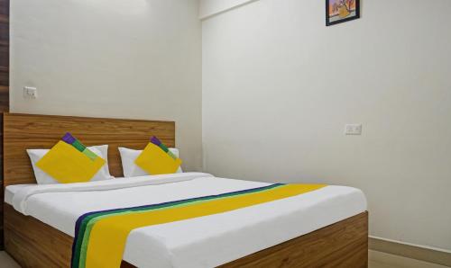a bedroom with a bed with colorful pillows at Itsy Hotels AY Plus Hotels in Kharadi