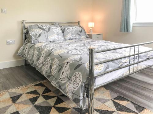 a bed with a metal frame in a bedroom at Ballygroggan Bungalow - Uk38174 in Machrihanish