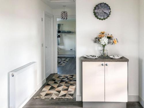 a hallway with a vase of flowers on a counter at Ballygroggan Bungalow - Uk38174 in Machrihanish