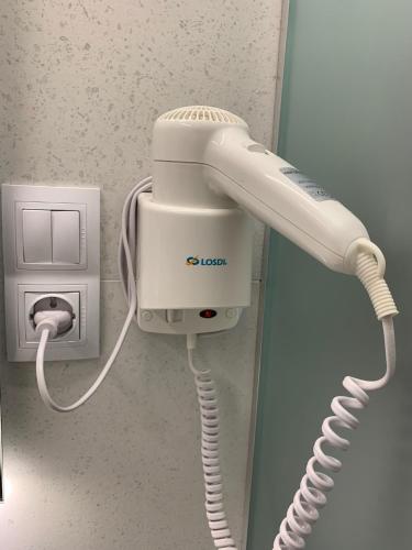 a white phone is plugged into a wall at Apartment OneClickRenrt Oasis in Chişinău