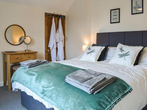 a bedroom with a bed with towels on it at Peppercorn Cottage in Enderby