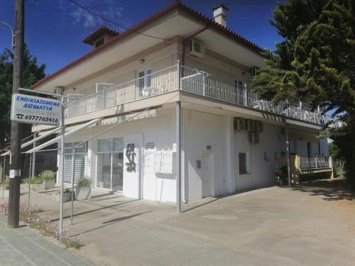 a white building with a balcony on top of it at KALIPSO STUDIOs in Nikiti