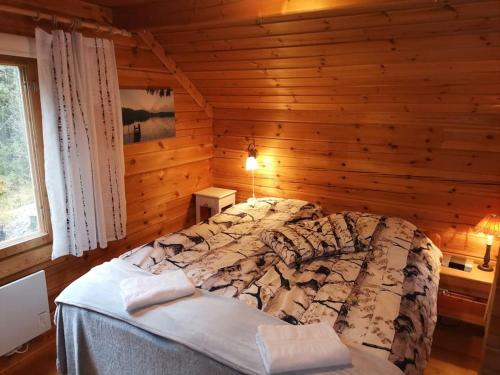 a bedroom with a bed in a log cabin at Casa di Sanna in Orimattila