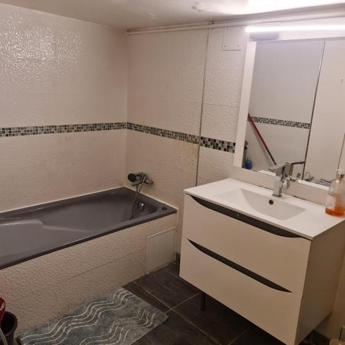 une salle de bain avec un lavabo et une baignoire dans l'établissement SAINT DENIS PARIS STADE de FRANCE DISNEY, à Saint-Denis
