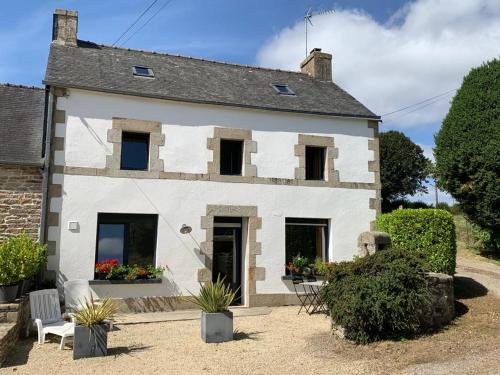 a white house with windows and plants in front of it at longère de kervéguen ARGOAT in Leuhan