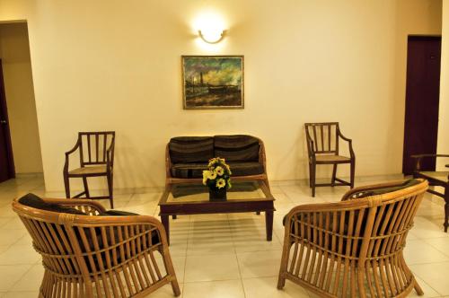 a room with chairs and a table with flowers on it at Hotel Sunflower in Kataragama