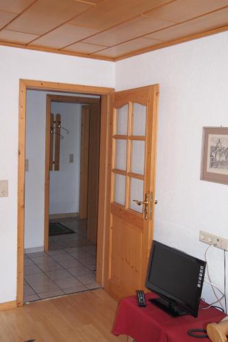 a room with a door and a television on a table at Haus Bergwelt in Grän