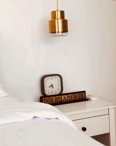 a clock on a wall next to a bed at Bintana Sa Paraiso in Mambajao