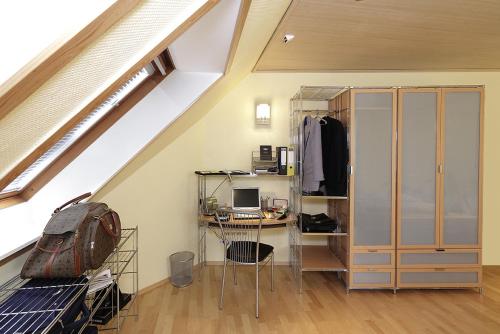 a attic room with a desk with a computer at Management - Business Suiten in Dortmund