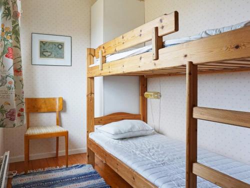 a bedroom with two bunk beds and a chair at 8 person holiday home in STRÖMSTAD in Strömstad