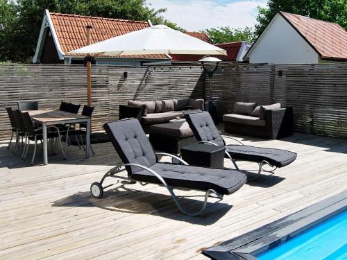 una terraza con sillas, una mesa y una sombrilla en 4 person holiday home in MALM en Malmö