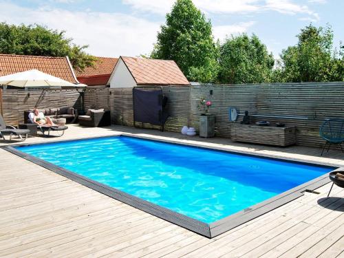 a large blue swimming pool on a wooden deck at 4 person holiday home in MALM in Malmö