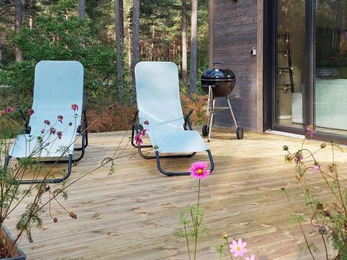 2 sillas sentadas en una terraza con parrilla en 7 person holiday home in STENKYRKA, en Stenkyrka
