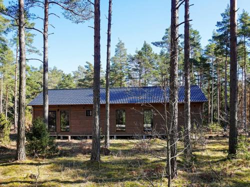 una cabaña de madera en el bosque con árboles en 7 person holiday home in STENKYRKA, en Stenkyrka