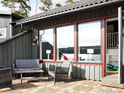 a patio with chairs and a table and windows at 5 person holiday home in str mstad in Strömstad