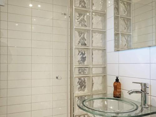 uma casa de banho com um lavatório e uma parede com um bloco de vidro em Holiday home Tanumshede IX em Tanumshede