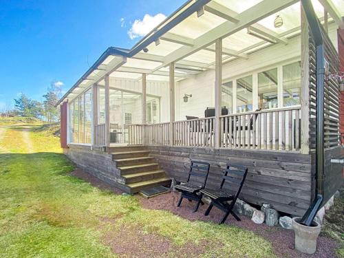 ein Haus mit einer Veranda und einer Bank auf dem Rasen in der Unterkunft 6 person holiday home in FIGEHOLM in Figeholm