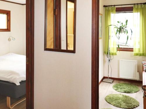 1 dormitorio con cama y espejo en la pared en Holiday home KNÄRED, en Knäred