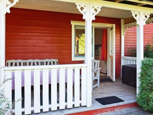 un porche de una casa roja con una valla blanca en 6 person holiday home in TORSBY, en Överbyn