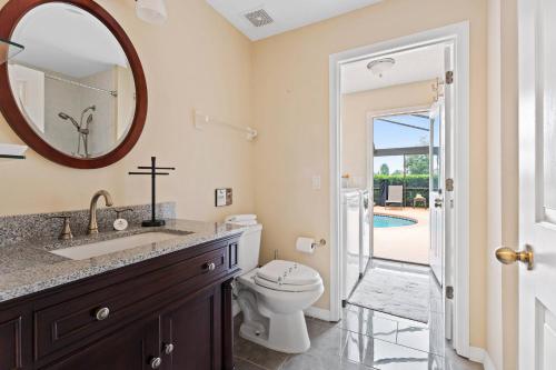a bathroom with a sink and a toilet and a mirror at Single Family no Stairs 4BR Kissimmee OI2800 in Orlando