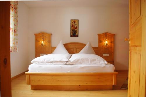 a bedroom with a bed with white sheets and pillows at Appartement Ilse in Sankt Anton am Arlberg