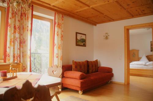 a living room with a red couch and a window at Appartement Ilse in Sankt Anton am Arlberg