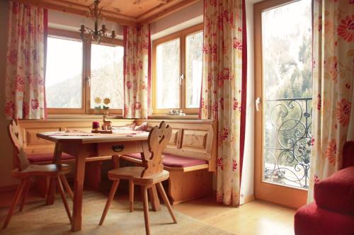 a table and chairs in a room with windows at Appartement Ilse in Sankt Anton am Arlberg