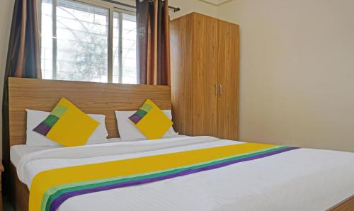a large bed with a rainbow blanket on it at Itsy Hotels AY Plus Hotels in Kharadi