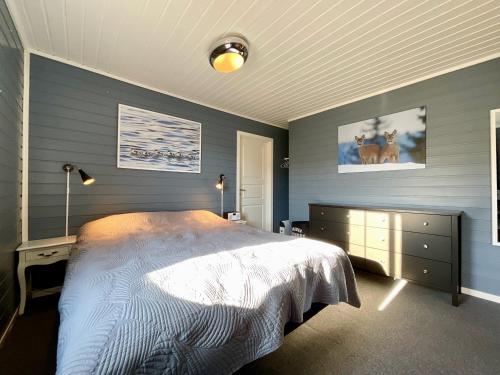 ein Schlafzimmer mit einem großen Bett und blauen Wänden in der Unterkunft Wildlife Panorama Lofoten in Bøstad