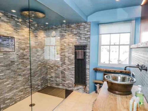 a bathroom with a sink and a glass shower at Bank Chambers in Bowness with Hot Tub and Lake Access in Bowness-on-Windermere