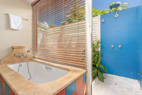 a bathroom with a bath tub and a window at Les Villas du Lagon in Le François