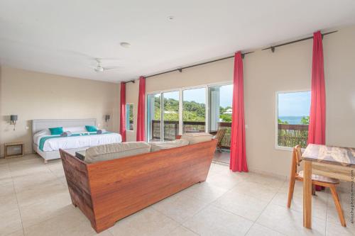 a bedroom with a bed and a couch in a room at Les Villas du Lagon in Le François