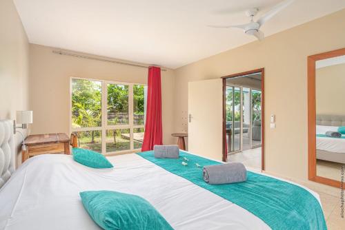 a bedroom with a large bed with green pillows at Les Villas du Lagon in Le François