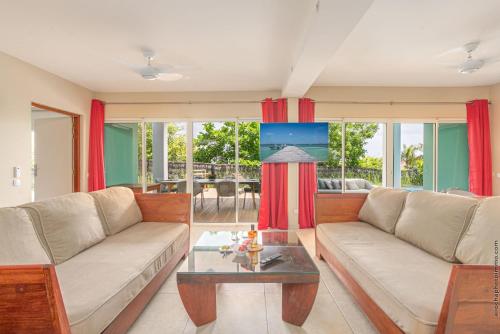 a living room with two couches and a table at Les Villas du Lagon in Le François