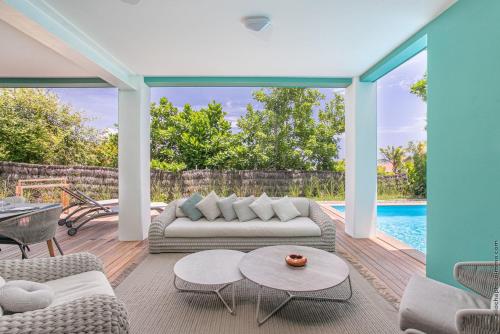 a living room with a couch and chairs and a pool at Les Villas du Lagon in Le François