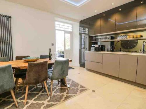 a large kitchen with a wooden table and chairs at Bank Chambers in Bowness with Hot Tub and Lake Access in Bowness-on-Windermere