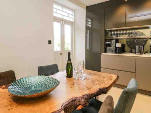 a kitchen with a table with a bottle of wine at Bank Chambers in Bowness with Hot Tub and Lake Access in Bowness-on-Windermere