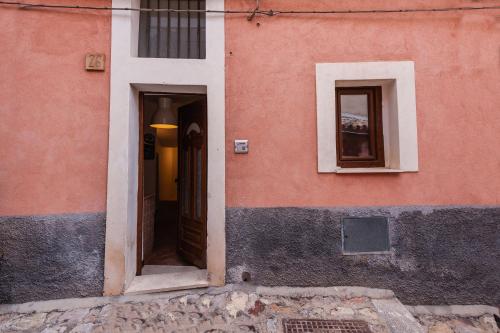 a pink building with a door and two windows at TAORMINA - The Godfathers Little Mansion in Forza dʼAgro