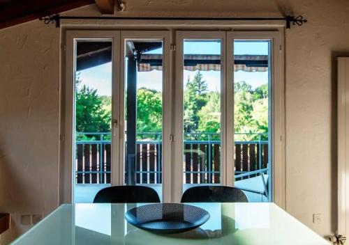 a dining room table with a view of a balcony at Casa Rogoria - Intimo rifugio con terrazza e caminetto in Astano