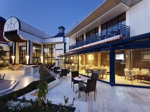 パムッカレにあるスパ ホテル コロッセア テルマルの建物内のテーブルと椅子のあるレストラン