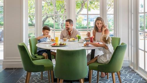 a family sitting around a table eating dinner at InterContinental Sanctuary Cove Resort by IHG in Gold Coast