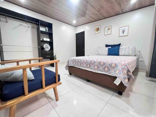 - une chambre avec un lit et un banc dans l'établissement Departamento H González 2, à El Coco
