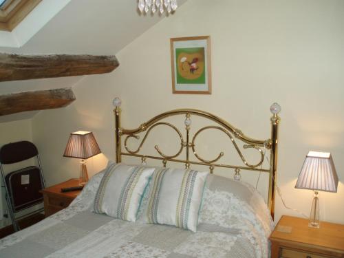 a bedroom with a bed with two lamps and a mirror at Foxhill Barn in Gisburn