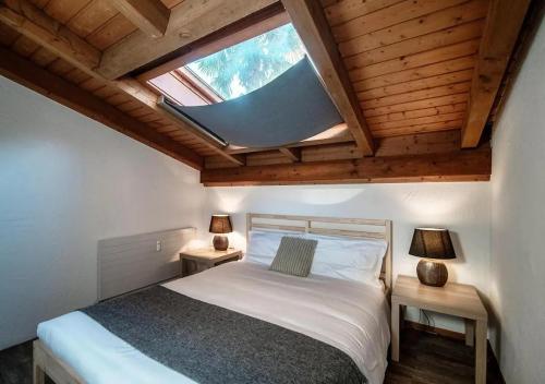 um quarto com uma cama grande e uma clarabóia em Casa Rogoria - Intimo rifugio con terrazza e caminetto em Astano