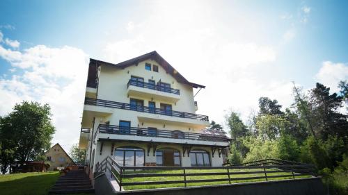 um grande edifício branco com varandas azuis em Pensiunea Toscana em Brasov