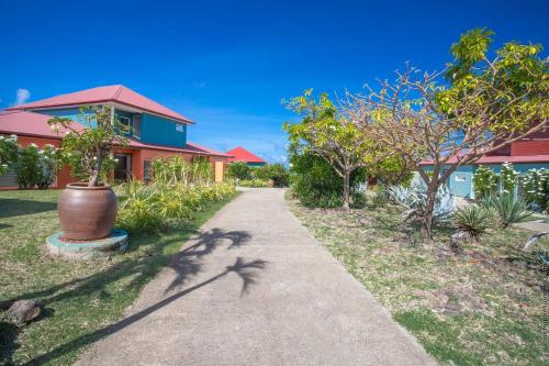 a path in front of a house with a plant at Les Villas du Lagon in Le François
