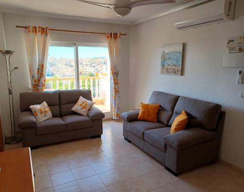 ein Wohnzimmer mit 2 Sofas und einem Fenster in der Unterkunft Molino Blanco Penthouse 15 in Playas de Orihuela