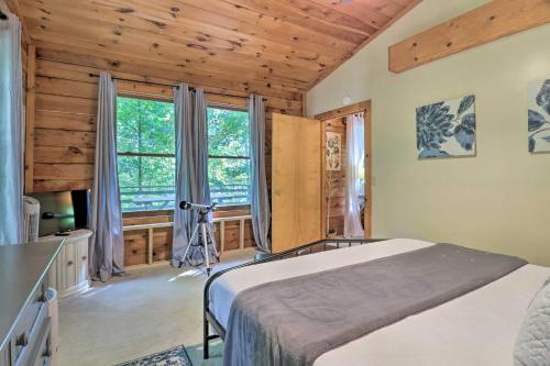 ein Schlafzimmer mit einem Bett und einem großen Fenster in der Unterkunft Rustic-Yet-Cozy Cabin with Fire Pit in Smokies! in Waynesville
