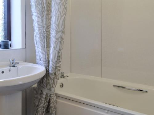 łazienka z umywalką i zasłoną prysznicową w obiekcie Beuchan Bungalow w mieście Closeburn