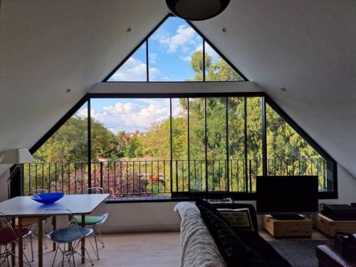 London Sky Home - stunning 3 bed apt in the Sky في لندن: نافذة كبيرة في غرفة المعيشة مع أريكة وطاولة